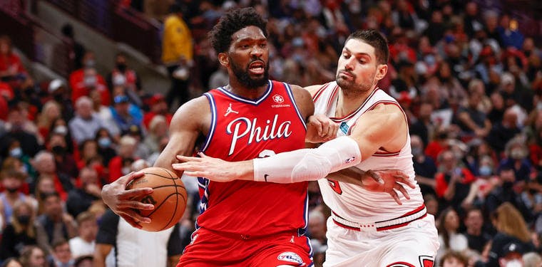 Joel Embiid gets fouled by Nikola Vucevic during a November 2021 NBA game in Chicago.