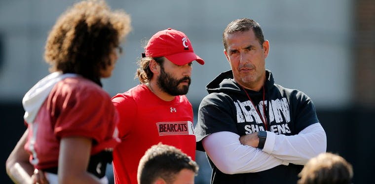 Luke Fickell checks in with the quarterbacks during the first day of training camp