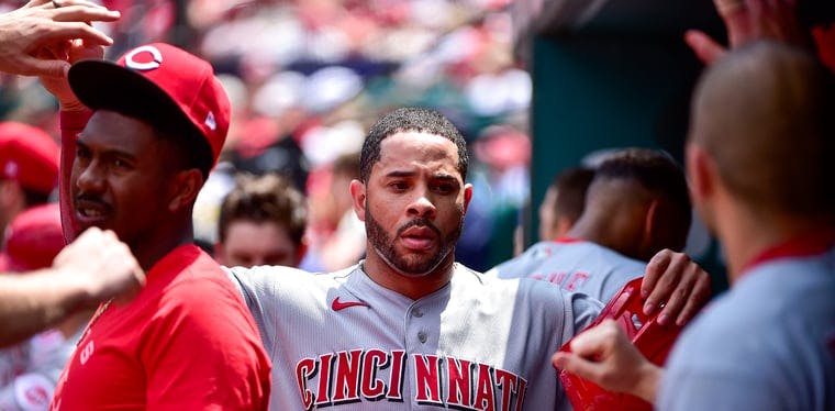 Reds outfielder Tommy Pham is congratulated by teammates after scoring against the Cardinals