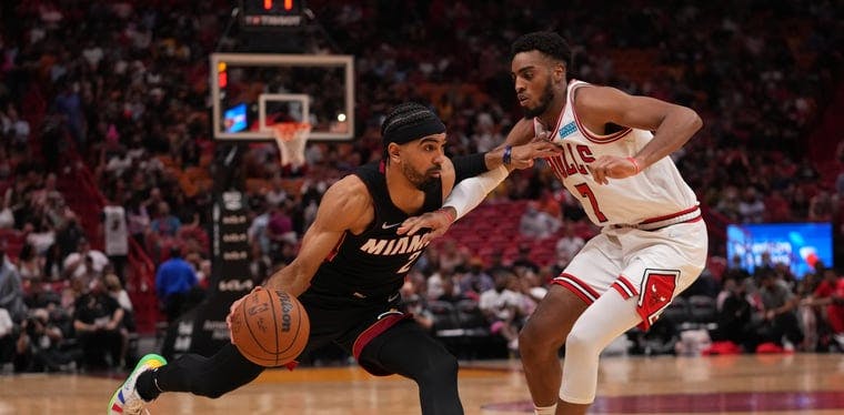 Miami Heat guard Gabe Vincent (2) drives the ball around Chicago Bulls forward Troy Brown Jr. (7) in an NBA matchup from December of 2021.