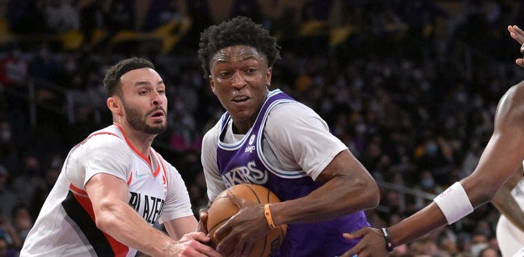 Stanley Johnson (in purple and blue) drives past the TrailBlazers Larry Nance Jr. (in white) in an earlier 2021-22 NBA contest.