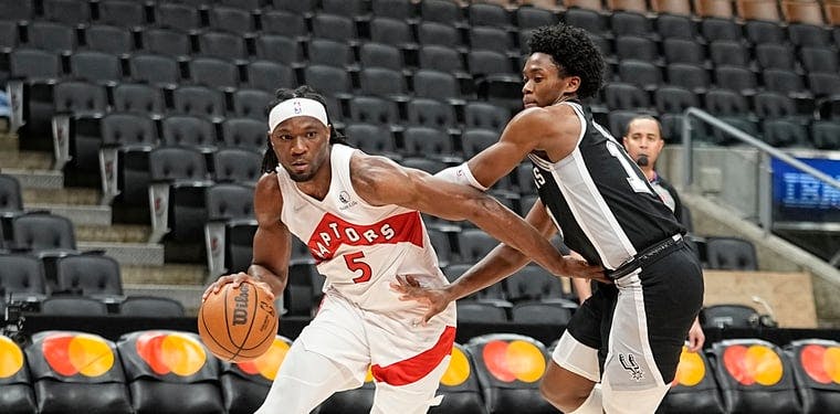 Toronto Raptors forward Precious Achiuwa (5) drives against Spurs guard Joshua Primo (11) in a 2022 NBA contest.