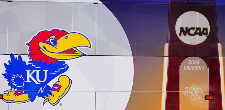 A detail view of the Kansas Jayhawks and NCAA branded bus wrap as the team arrives before the 2022 NCAA men's basketball tournament Final Four in New Orleans, LA.