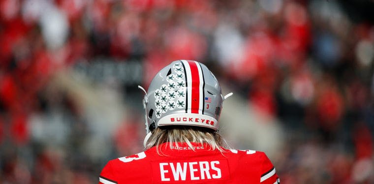 Former Ohio State Buckeyes quarterback Quinn Ewers practices on the sideline