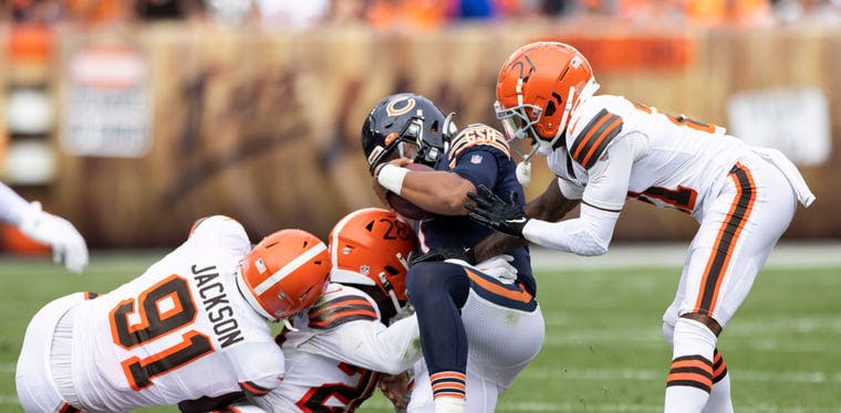 Bears quarterback Justin Fields slides as he is hit by Browns linebacker Jeremiah Owusu-Koramoah