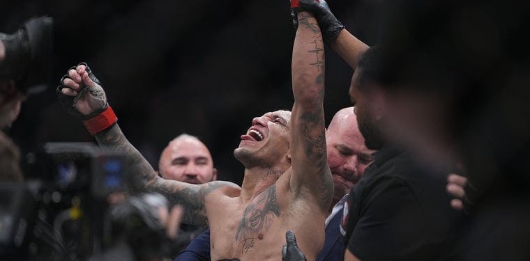 Charles Oliveira celebrates his victory by submission against Dustin Poirier during UFC 269