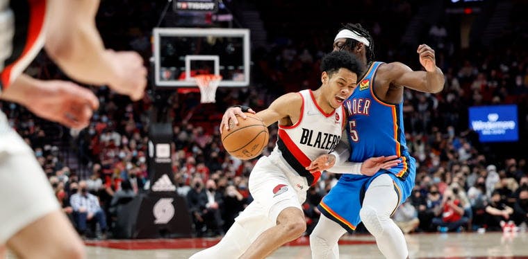 Portland Trail Blazers shooting guard Anfernee Simons (1) tries to drive the basket as he's guarded by Oklahoma City's Lugentz Dort (5) during an NBA contest at Moda Center in Portland, Oregon.