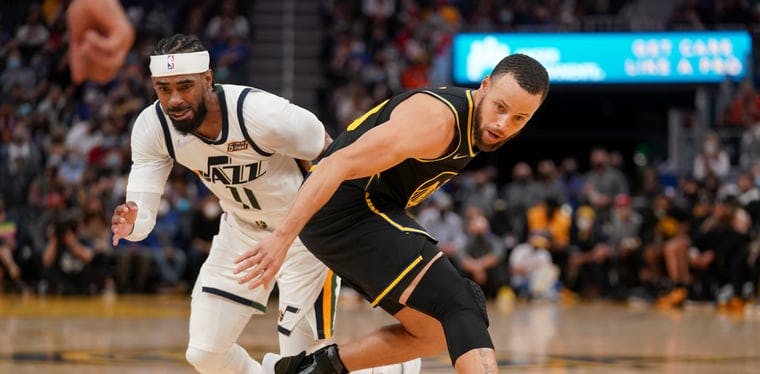 Mike Conley and Steph Curry chase a loose ball at the Chase Center