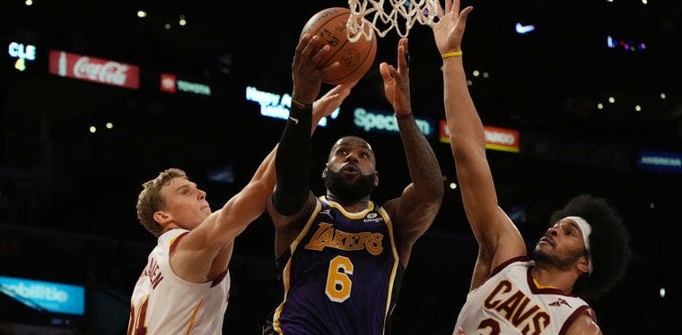 Los Angeles Lakers forward LeBron James (6) moves in for a tough basket against the Cleveland Cavaliers front court of Lauri Markkanen and Jarrett Allen