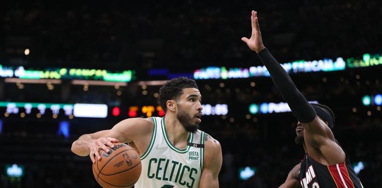  Celtics forward Jayson Tatum looks to move the ball defended by Miami Heat forward Jimmy Butler