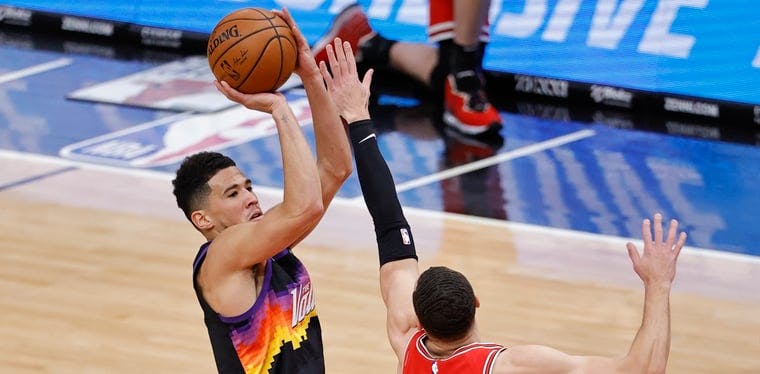 Devin Booker of the Suns shoots a jump shot over Zach Levine in a February 2021 contest at the United Center in Chicago.