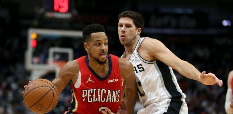 The newly acquired Pelicans guard CJ McCollum drives the basketball against the Spurs' Doug McDermott in a February 12th game at the Smoothie King Center