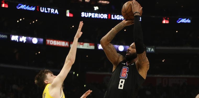 Los Angeles Clippers forward Marcus Morris Sr. (8) takes a shot over Los Angeles Lakers guard Austin Reaves (15) in a 2022 NBA contest.