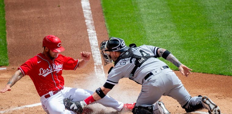 Cincinnati Reds center fielder Nick Senzel (15) is tagged out by Yasmani Grandal in a game against the Chicago White Sox.