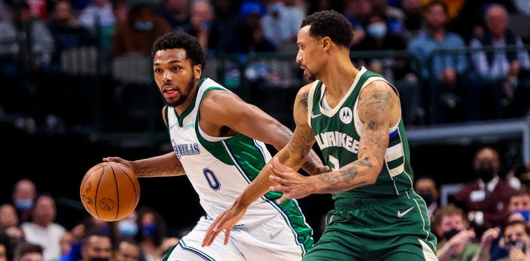 Dec 23, 2021; Dallas, Texas, USA; Dallas Mavericks forward Sterling Brown (0) dribbles as Milwaukee Bucks guard George Hill (3) defends during the second half at American Airlines Center. 