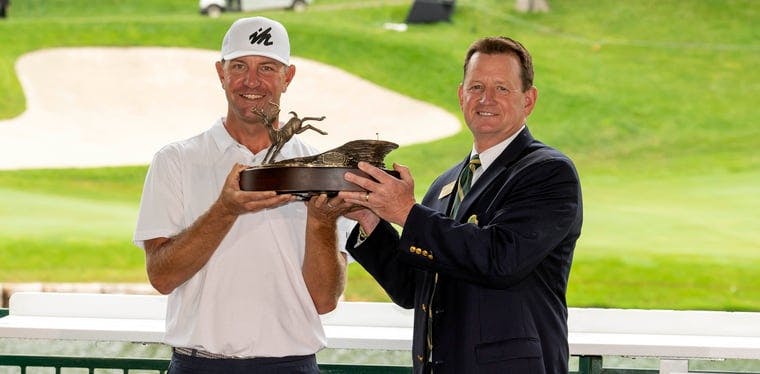 Lucas Glover holds up the championship trophy after the John Deere Classic golf tournament